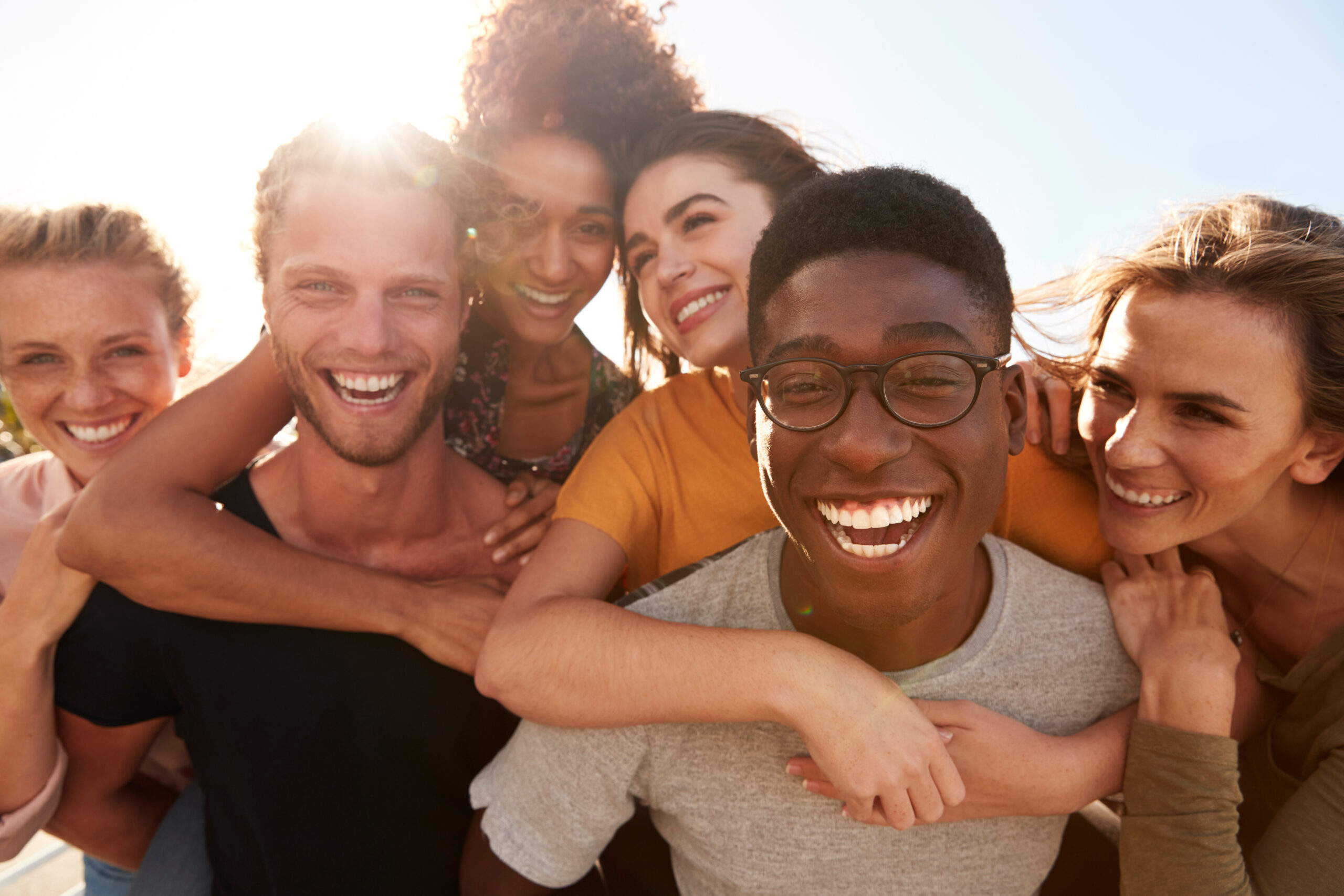 Portrait Of Smiling Young Friends Walking Outdoors Together