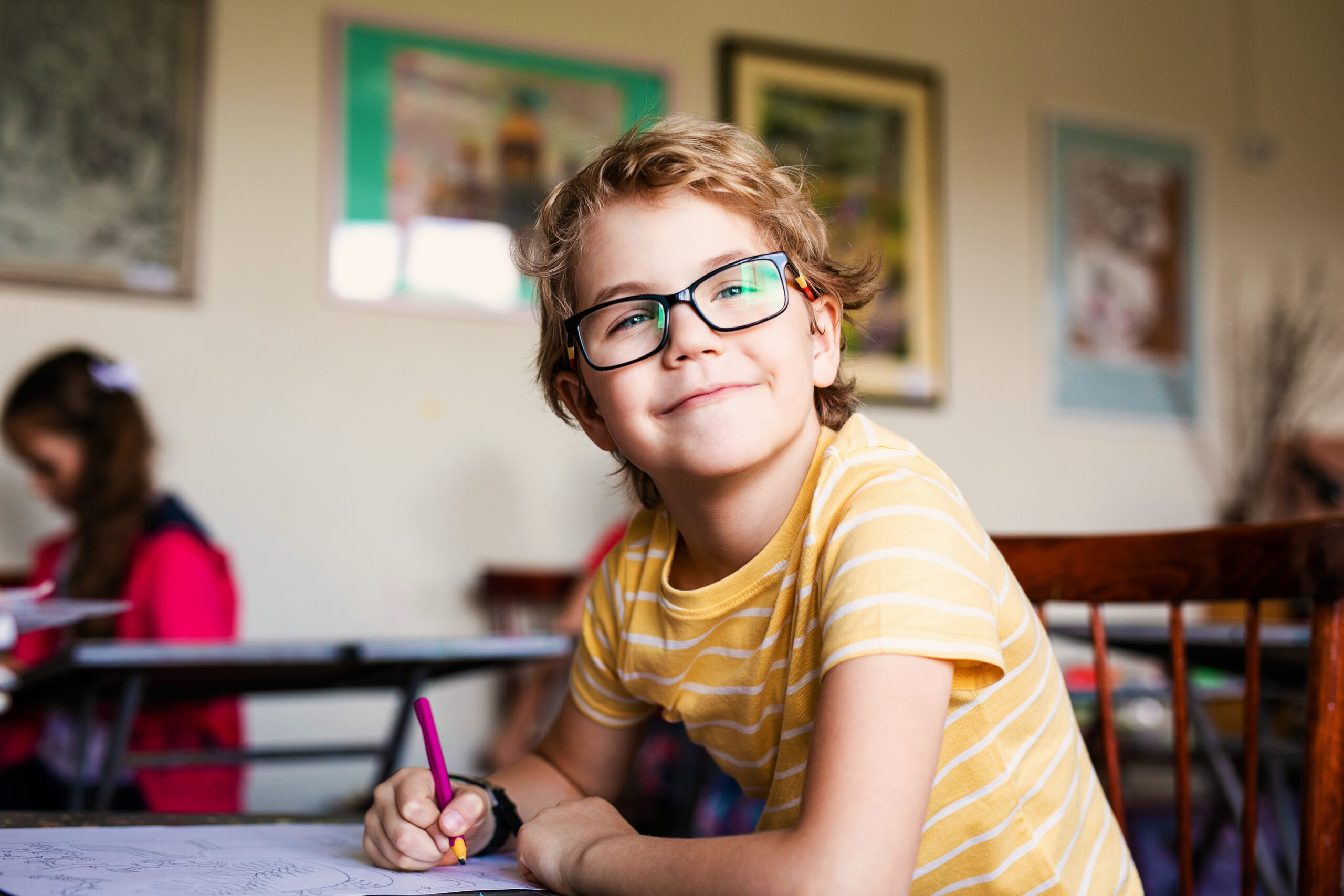 Blonde boy with glasses drawing. Group of elementary school pupils in classroom on art class. Russia, Krasnodar, May, 23, 2019.