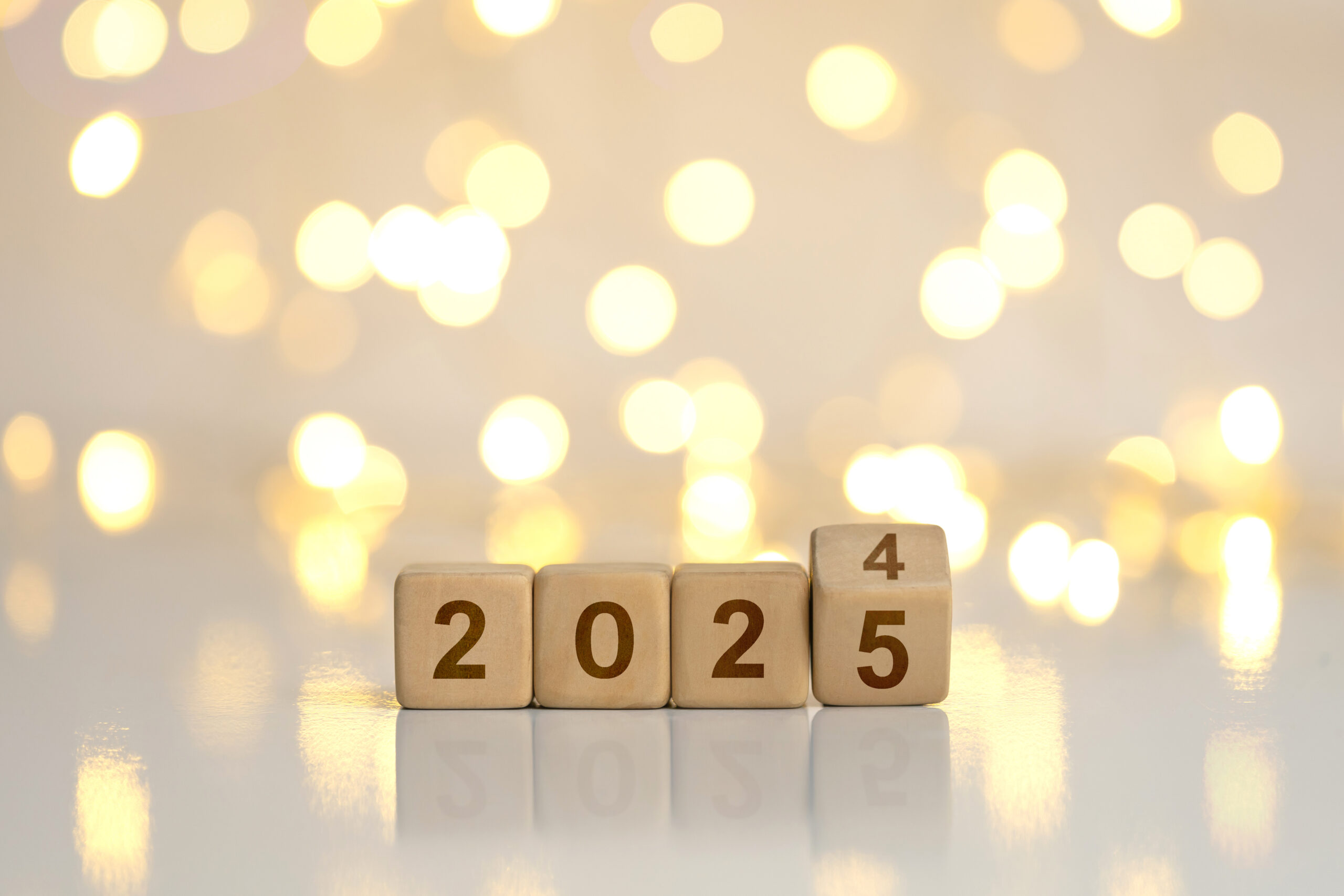 New Year Goals 2025. Flipping numbers 2024 to 2025 on a wooden block cube on a light bokeh background for preparation for the New Year change holiday. Happy New Year 2025.new Year's Eve Celebration.