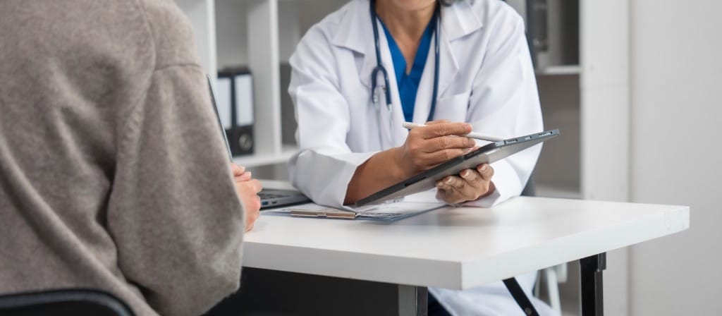 Clinician reviewing information on a tablet with a patient